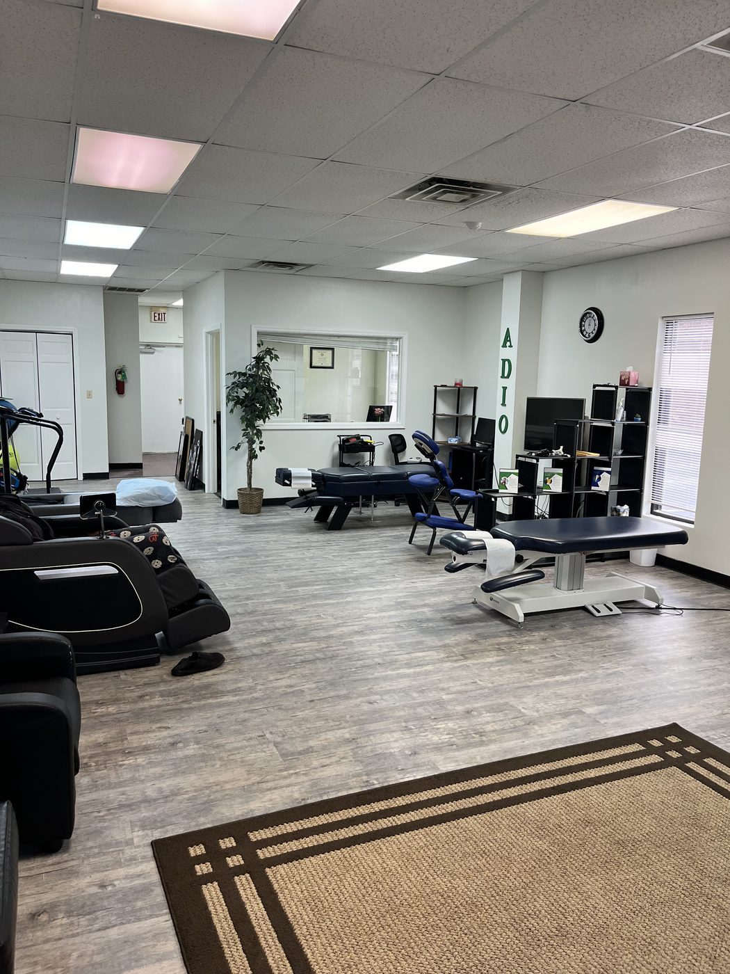 Open treatment floor at BioSpine Health and Wellness with adjustment tables, massage chairs, and rehabilitation equipment